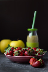 kiwi and apple smoothies on a dark background on a marble table with strawberries