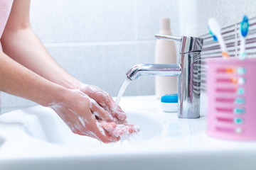 Washing hands with soap under the tap with water in bathroom. Hygiene, protection and prevention against viruses and bacteria