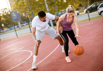 Group of multiethnic people  playing basketball on court