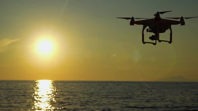 The drone in the sunset sky. ocean wave mountains Close up of quadrocopter outdoors. concept for film maker wedding videography aerial photographer. equipment for vlog blog, old,