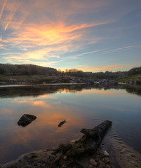 Fototapeta premium Sunset with golden clouds reflected in the river