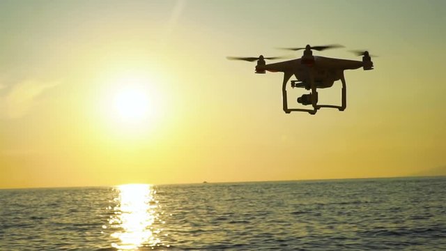 The drone in the sunset sky. ocean wave mountains Close up of quadrocopter outdoors. concept for film maker wedding videography aerial photographer. equipment for vlog blog, old,