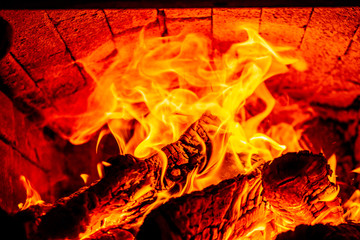 Fire wood burning with open flame in an old brick furnace isolated