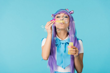 Asian anime girl in purple wig with soap bubbles isolated on blue