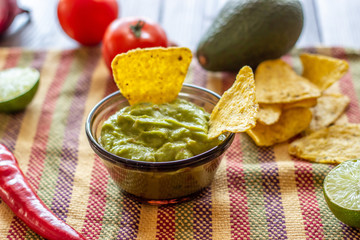 Guacamole and chips nachos in the colored napkin. Mexican cuisine.