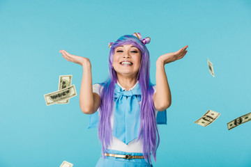 Excited asian anime girl with dollar banknotes isolated on blue