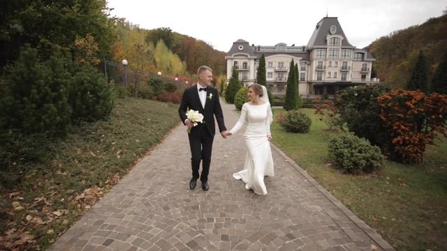 Beautiful couple walking in the park. Groom and bride run