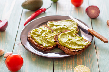 Sandwiches with avocado on the blue wooden background.