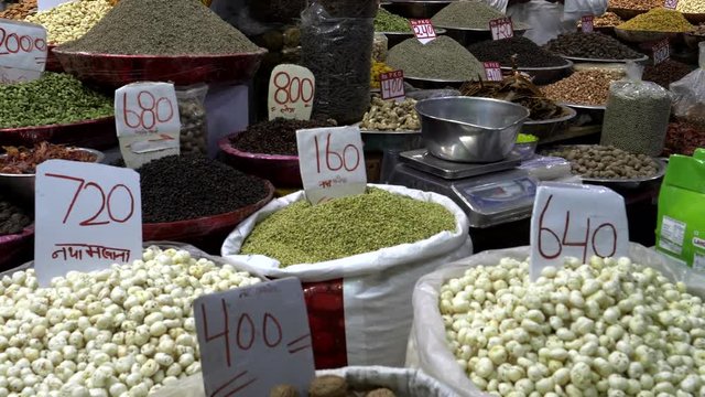 a panning shot of dried fruit and nuts on display at chandni chowk spice market in old delhi, india