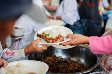 Poor people receive donated food from donors, Demonstrate mutual sharing in today's society : Beggar begs food from donors