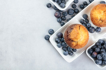 Muffins and blueberry on white table.