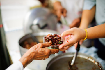 Poor people receive donated food from donors, Demonstrate mutual sharing in today's society :...