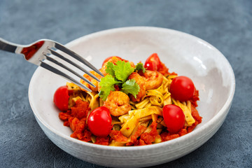 Cooked pasta with peeled shrimp, coconut milk sauce and broccoli