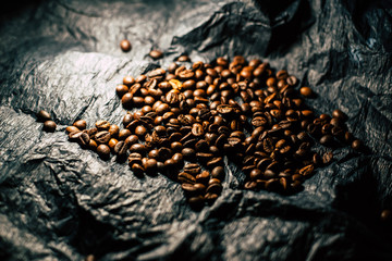 Coffee grains on a black background with a cup