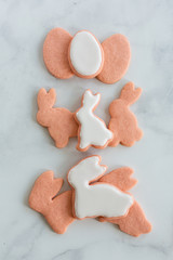 Pink Bunny and Egg Sugar Cookies with White Royal Icing on Marble Backdrop