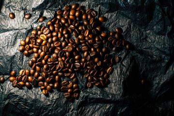 Coffee grains on a black background with a cup