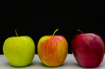 Red, Green and Jonathan apples on black background