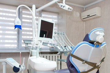 Dentist office. Modern dental cabinet. Dental instruments and tools in modern clinic, professional dentistry chair waiting to be used by orthodontist