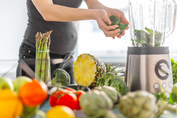 Pregnant woman cooking healthy smoothie