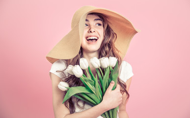 girl in a hat and tulips on a colored background