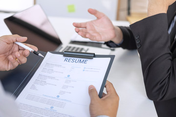 Employer or recruiter holding reading a resume during about colloquy his profile of candidate, employer in suit is conducting a job interview, manager resource employment and recruitment concept