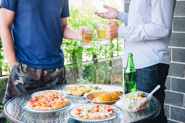 Two young man hand raise a glass of beer to celebrate the holiday festival happy drinking beer outdoors and enjoying at home