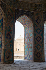 Fototapeta na wymiar Symmetrical decorative ornament of entrance to the tomb and open door in Shah-I-Zinda, a memorial complex, necropolis in Samarkand, Uzbekistan