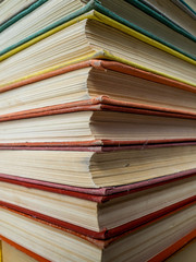 Heap of books of different flowers. The old books put on a table. The turned yellow pages of textbooks