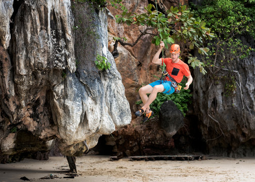 Thailand, Krabi, Lao Liang, climber abseiling from rock wall