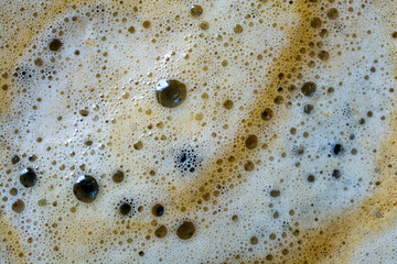 Freshly brewed coffee foam. Abstract background texture closeup.