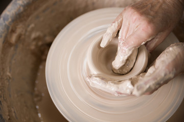 Women's hands and potter's wheel