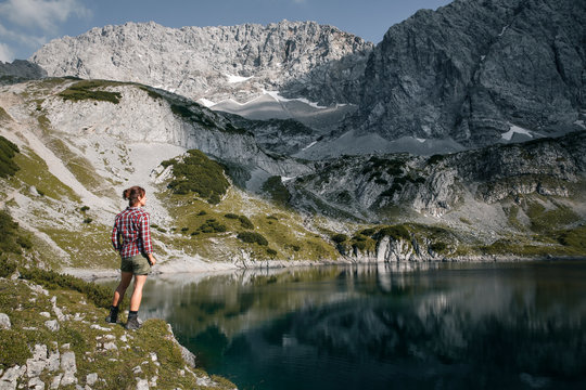 Austria, Tyrol, woman standing at lake Drachensee looking at view