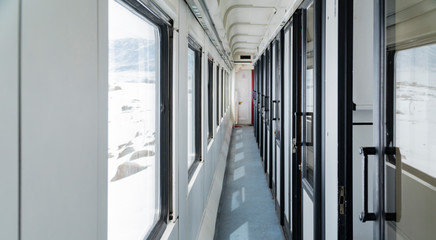 Empty corridor of passenger train in the daylight.