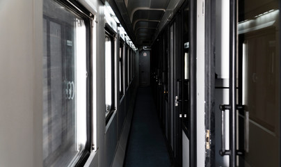 Empty corridor of passenger train in the dark.