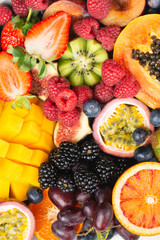 Delicious fruit background mango papaya oranges passion fruits berries, overhead view, selective focus, copy space