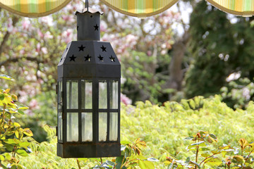 Lampe hängend auf der Terrasse mit Blick auf den Garten und Markise