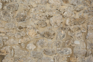 Old beige stone wall background texture close up