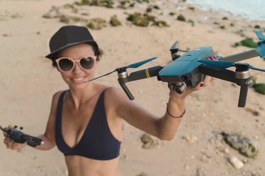 Indonesia, Bali, Nusa Dua, woman holding drone at the beach