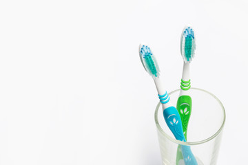Set of toothbrushes in glass on white background.