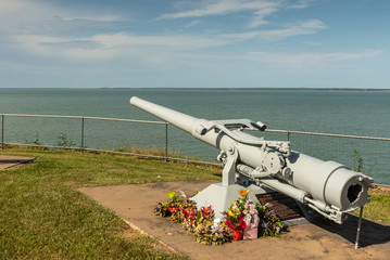 Darwin Australia - February 22, 2019: USS Peary war memorial in Bicentennial park along shore of Darwin Harbour has cannon pointing to the place where the Clemson-class destroyer rests under the water