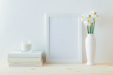Home interior with decor elements. White frame, white daffodils in a vase, interior decoration