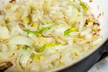 Sliced onion fried in a frying pan
