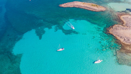 Amazing drone aerial landscape of the charming area of Es Trencs and the boats with a turquoise sea. It has earned the reputation of Caribbean beach of Mallorca. Spain