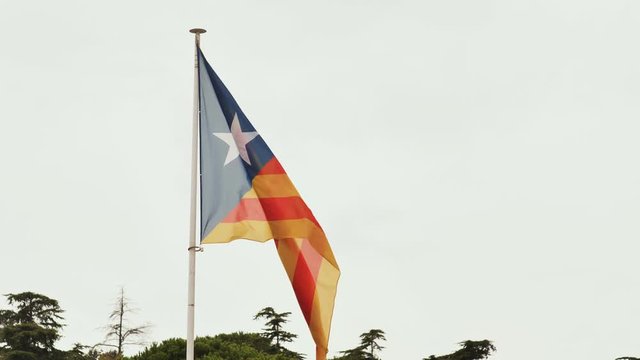 Flag of Catalonia against the blue sky.