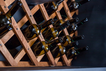 Fototapeta premium empty bottles decorative on the shelfs.interior decorative elements.decorative wall. creative interior design of the bar, restaurant, hotel. Abstract decorative design.Glass bottles in wooden boxes