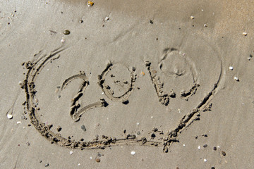 sea wave blurred pattern and the year 2019 in the sand