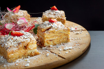 Four piece of cake Napoleon on wooden tray. Russian cuisine, layered cake with pastry cream.