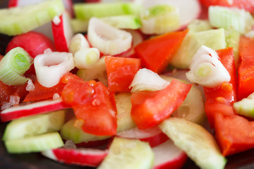 Close up of halthy vegetable salad of fresh tomato, cucumber, onion and red radish. Diet menu.