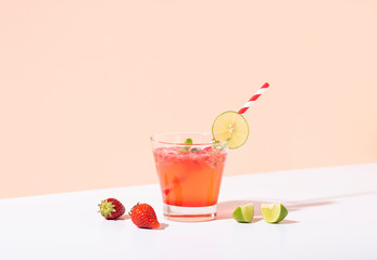 iced strawberry punch cocktail in glass with lemon on color background. summer drink.