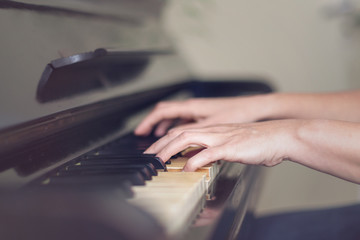 Close up of two hands playing piano, shallow focus.